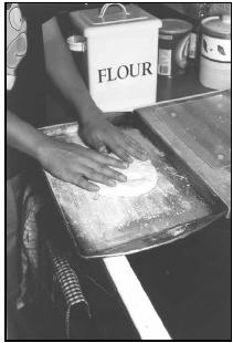 To make Damper (European Style), shape dough into a large flat circle on a greased and floured baking sheet. EPD Photos