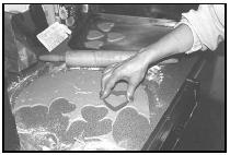 After rolling out the dough, cut the lebkuchen into shapes such as hearts or teddy bears. If the cookies are to be hung by a ribbon, pierce one or two holes in the dough near the top of the cookie. EPD Photos