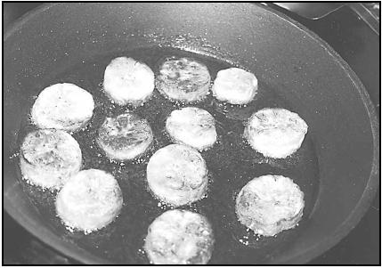 Dodo (fried plantain slices) sizzle in the frying pan. Fried plantains are often served for breakfast or as a snack. EPD Photos