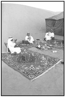 Saudis arrange ornate rugs around a central fire when outdoors, as these men are, or around dishes of food being served when indoors. Diners sit on the rugs and share food and conversation. EPD Photos/Brown W. Cannon III
