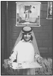 A young man presents coffee on a tray to a guest. The Saudis take pride in their hospitality, and it is considered rude to refuse a host's offer of refreshments. EPD Photos/Brown W. Cannon III
