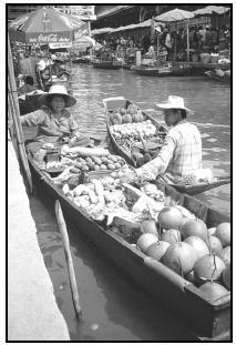 Thai fruit and vegetable vendors often sell their wares from long boats, moving from dock to dock to serve their customers. Cory Langley