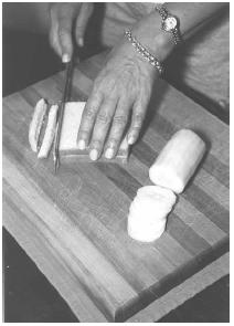 The crusts from thin-sliced white bread are trimmed to make cucumber sandwiches to serve at teatime. The cucumber is peeled and sliced thinly. EPD Photos